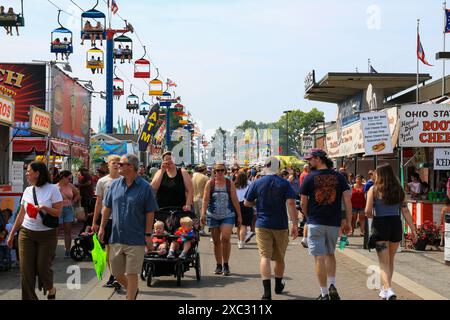 Columbus, Ohio, USA - 5 August 2023: A crowd of people and families walking on midway under the sky gliders at the Ohio State Fair Stock Photo