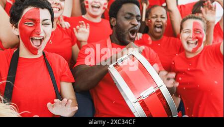 Sport fans screaming while supporting their team at stadium during euro competition - Football supporters having fun at sport event - Soft focus on le Stock Photo