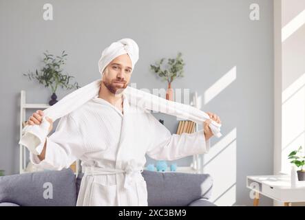 Portrait of man in white bathrobe and towel after taking shower and washing hair Stock Photo