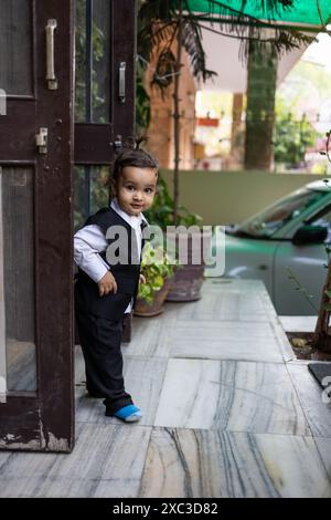 cute indian toddler baby boy in black suit at outdoor from different angle Stock Photo