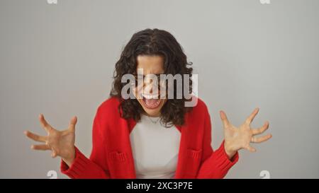 A beautiful young brunette hispanic woman wearing a red sweater passionately expressing herself over a white background. Stock Photo