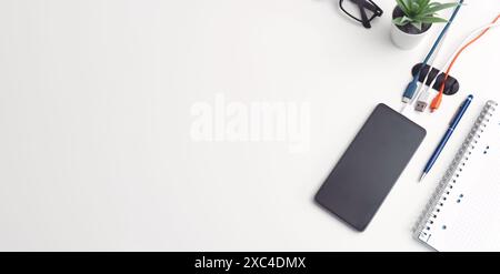 Office desktop with smartphone and accessories. Top view with copy space Stock Photo