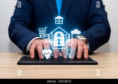 An unrecognizable man is typing on a keyboard with a padlock icon on it surrounded by icons of a house, a cloud, a lightbulb, heart and shopping cart. Stock Photo