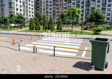 Applying road markings. Pedestrian crossing on the street in the yard. Cones Stock Photo