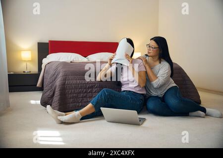 Woman hiding herself behind pile of documents in mother presence Stock Photo