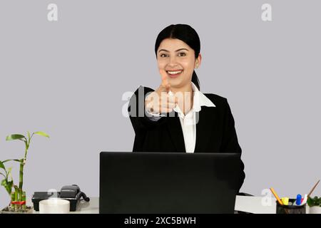 Beautiful Asian Indian Receptinist Entrepreneur with laptop, headphone and diary gives gestures  and expressions Stock Photo