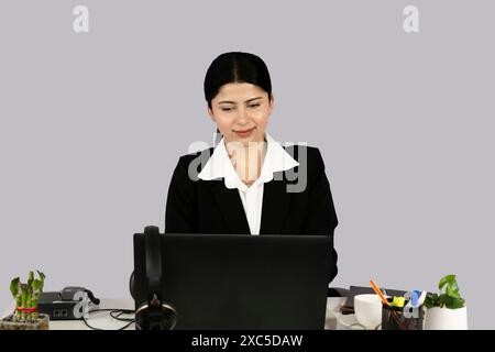 Beautiful Asian Indian Receptinist Entrepreneur with laptop, headphone and diary gives gestures  and expressions Stock Photo