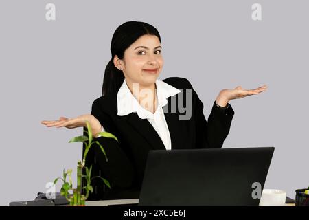 Beautiful Asian Indian Receptinist Entrepreneur with laptop, headphone and diary gives gestures  and expressions Stock Photo