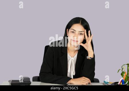 Beautiful Asian Indian Receptinist Entrepreneur with laptop, headphone and diary gives gestures  and expressions Stock Photo