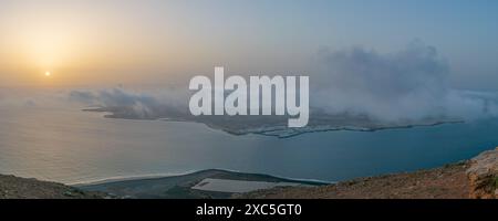 Panorama of coastal Sunrise Over Misty Harbor Stock Photo