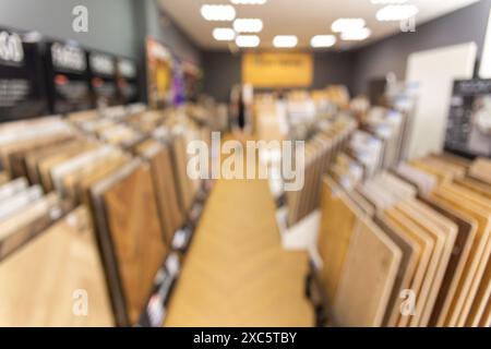 A blurred background image of the interior of a salon selling floor coverings. Assortment of laminated flooring samples in hardware store Stock Photo