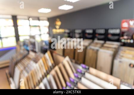 A blurred background image of the interior of a salon selling floor coverings. Assortment of laminated flooring samples in hardware store Stock Photo