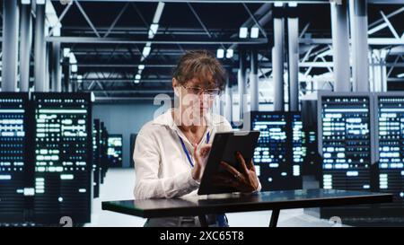 Focused IT practitioner working in high tech location housing GPU dedicated servers that can process AI tasks with high efficiency, diagnosing rigs used for machine learning showing hindrances Stock Photo
