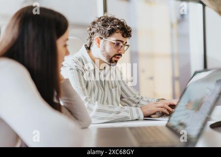 Diverse coworkers collaborating on project details for business expansion and profit growth in an office workspace. Stock Photo
