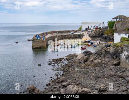The charming little fishing village of Coverack on the south Cornwall coast, England.  Fishing boats moored in the small harbour at low tide. Stock Photo