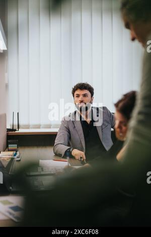 Focused male employee in a business meeting within a modern office setting Stock Photo