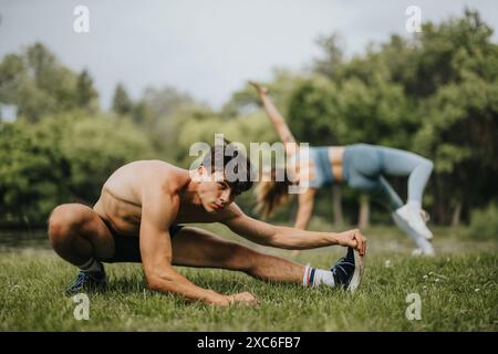 Young athletes stretching in a park, engaging in outdoor fitness and exercise Stock Photo