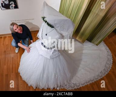 PRODUCTION - 12 June 2024, Brandenburg, Cottbus: Martina Noack, curator of the 'Tracht und Trend' exhibition at the Wendish Museum, can be seen wearing a cathedral wedding two-piece by fashion designer Sarah Gwiszcz (Wurlawy). The Wendish Museum Cottbus - Serbski muzej Chosebuz - presents the exhibition 'Tracht und Trend' from 15.06.2024. The traditional costume exhibition provides insights into the Sorbian and Wendish traditional costume culture of the present and presents the work of young designers who are inspired by traditional costumes for their fashion designs, but also presents the div Stock Photo