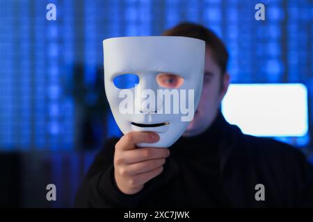 Hacker with mask in dark room, closeup Stock Photo