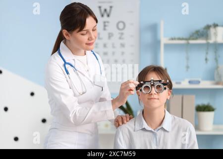 Female ophthalmologist putting trial frame on patient in clinic Stock Photo