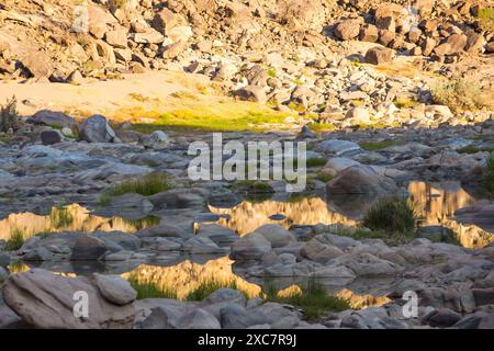 Golden Reflection of the cliffs of the Fish River Canyon into the river in the late afternoon. Stock Photo