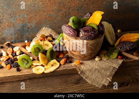 Dried tropical fruits with various nuts and raisins on a old wooden table. Stock Photo