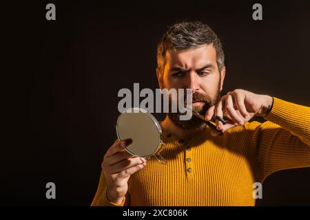 Barber scissors and mirror, barber shop. Cutting mustache and beard with barbers scissors. Beard Beauty Care Products. Cosmetics for bearded man with Stock Photo