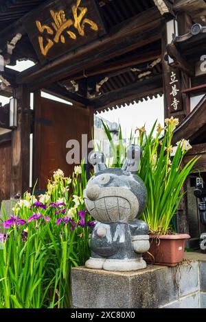 The entrance of Ryuzen-ji temple in Yanaka district, Tokyo, with a statue of Anpanman anime's character named 'Baikinman' Stock Photo