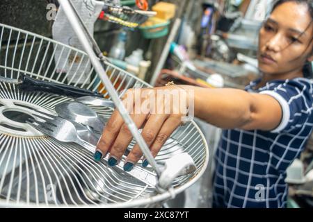 A woman washes dishes in an outdoor sink Stock Photo