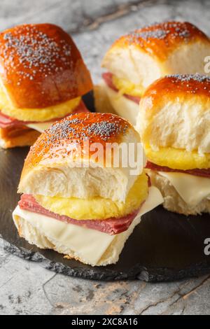 Ham and cheese sliders with a tropical twist a slice of pineapple closeup on the slate board on the table. Vertical Stock Photo