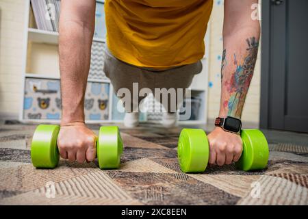 Man Doing Push Ups With Dumbbells At Home Stock Photo