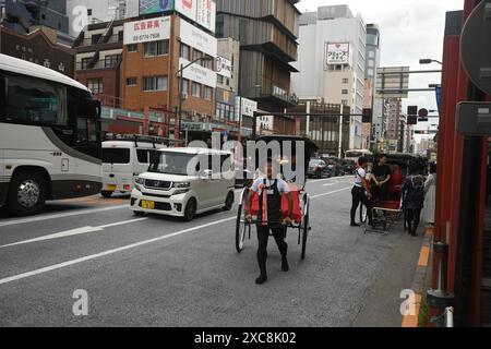 Japanese man carrying a typical japanese rickshaw with tourists on the ...