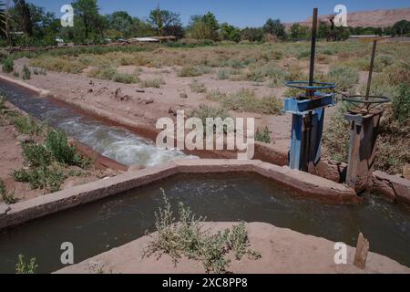 San Pedro de Atacama, Chile - Irrigation canals and pumps carrying water through agricultural land in the Atacama desert Stock Photo