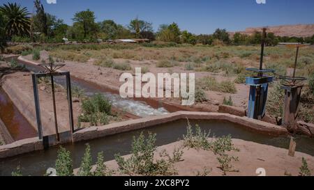 San Pedro de Atacama, Chile - Irrigation canals and pumps carrying water through agricultural land in the Atacama desert Stock Photo