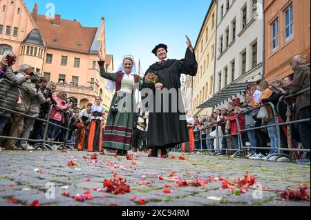 Lutherstadt Wittenberg, Germany. 15th June, 2024. The bridal couple Martin Luther and Katharina von Bora, portrayed by Carolin and Oliver Koschmieder, wave to the spectators at the edge of the procession. The Wittenberg festival 'Luther's Wedding' is taking place this weekend. On June 13, 1525, the former monk Martin Luther and the escaped nun Katharina von Bora married in Wittenberg. Credit: Heiko Rebsch/dpa/Alamy Live News Stock Photo