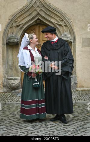 Lutherstadt Wittenberg, Germany. 15th June, 2024. The bridal couple Martin Luther and Katharina von Bora, portrayed by Carolin and Oliver Koschmieder in the courtyard of the Luther House. The Wittenberg festival 'Luther's Wedding' takes place this weekend. On June 13, 1525, the former monk Martin Luther and the escaped nun Katharina von Bora married in Wittenberg. Credit: Heiko Rebsch/dpa/Alamy Live News Stock Photo