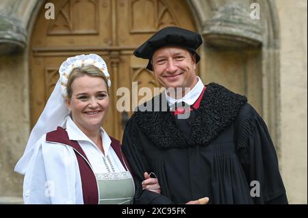 Lutherstadt Wittenberg, Germany. 15th June, 2024. The bridal couple Martin Luther and Katharina von Bora, portrayed by Carolin and Oliver Koschmieder in the courtyard of the Luther House. The Wittenberg festival 'Luther's Wedding' takes place this weekend. On June 13, 1525, the former monk Martin Luther and the escaped nun Katharina von Bora married in Wittenberg. Credit: Heiko Rebsch/dpa/Alamy Live News Stock Photo