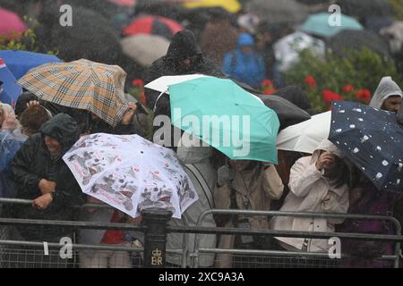 London, UK. 15th June, 2024. In a mix of torrential rain, thunder & lightning, and finally sunshine, Trooping the Colour for the King’s Official Birthday Parade takes place with Catherine, Princess of Wales, attending. Crowds remain enthusiastic despite the weather conditions. Credit: Malcolm Park/Alamy Live News Stock Photo