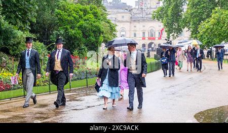 London UK 15th June 2024 - Guests with umbrellas still smiling despite getting soaked in torrential rain after  the Trooping the Colour in London today .  : Credit Simon Dack / Alamy Live News Stock Photo