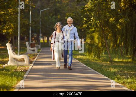Happy senior couple walking in the park enjoying retirement and spending time together. Stock Photo