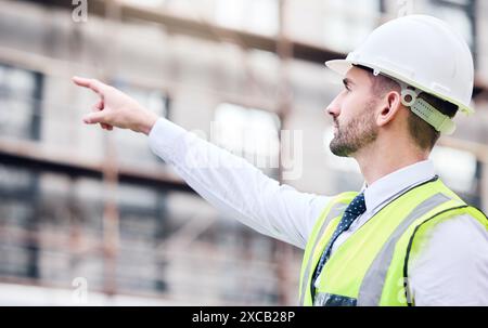 City, man and engineer pointing to construction site for real estate development with ppe safety and project management. Architect guy, hand and Stock Photo