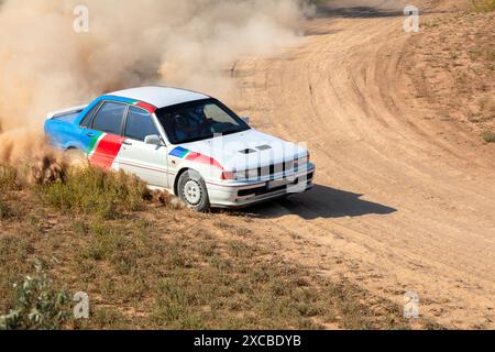 Sunny summer day. Dirt rally track. Rally car creates a lot of dust on a turn Stock Photo