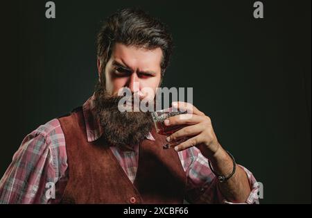 Bartender leather apron holding whisky cocktail in glass. Old traditional whiskey drink - gentlemen beverage. Stock Photo