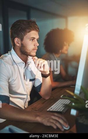 Computer, planning and businessman in office at night with research for coding on website with deadline. Thinking, ideas and male software developer Stock Photo