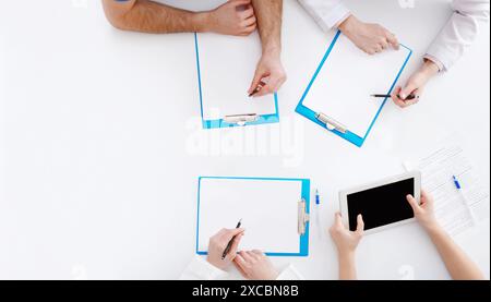 Medical Education. Doctors Writing On Clipboards At Seminar Stock Photo