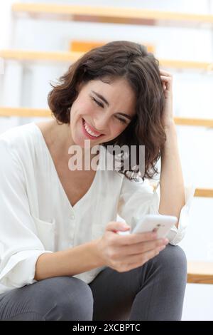 Woman sitting on stairs and using smart phone Stock Photo