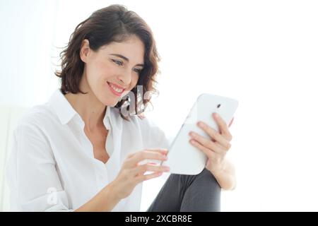 Woman using tablet computer and smiling Stock Photo