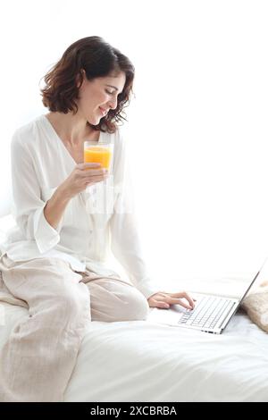 Woman using laptop computer and smiling Stock Photo