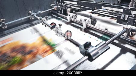 Machine, paper and printing in warehouse for distribution or production for magazine, newspaper or publishing. Industrial printer, press and wholesale Stock Photo