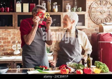 Senior Couple Having Fun in Kitchen With Red Radishes Stock Photo